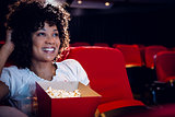 Smiling young woman watching a film