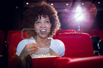 Smiling young woman watching a film