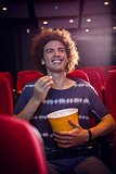 Smiling young man watching a film
