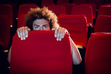 Young man watching a scary film