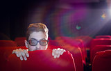 Young man watching a scary 3d film