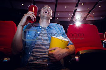Happy young man watching a film