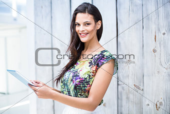 Smiling beautiful brunette using her tablet