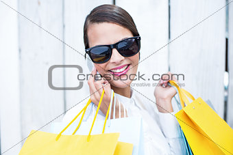 Pretty woman on the phone holding shopping bags
