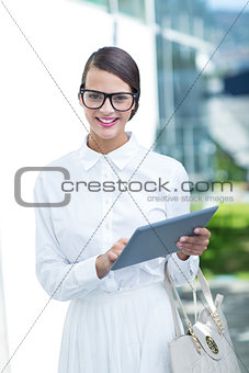 Pretty woman using her tablet pc looking at camera