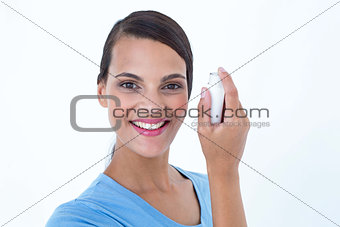 Smiling woman using her inhaler