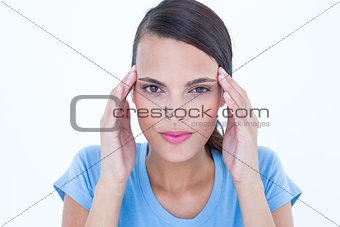 Pretty woman with headache touching her temples looking at camera