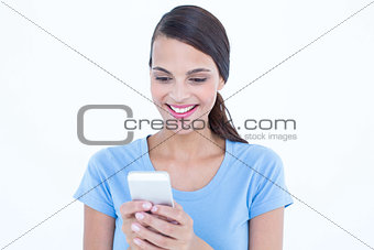 Happy brunette looking at her smartphone