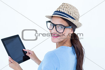 Smiling woman using her tablet looking at camera