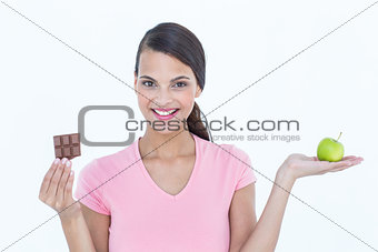 Pretty woman holding chocolate bars and an apple