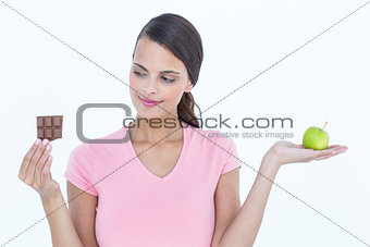 Pretty woman holding chocolate bars and an apple