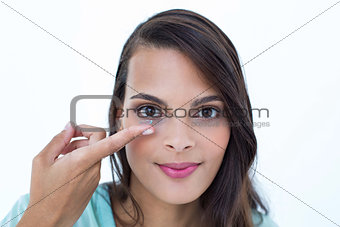 Beautiful woman applying contact lens