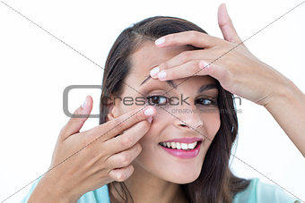 Beautiful woman applying contact lens