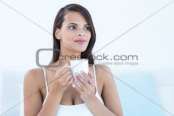Thoughtful woman holding cup of coffee