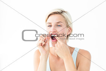 Blonde woman flossing