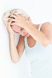 Sad blonde woman with head pain holding her head