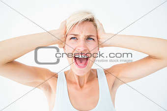 Angry blonde screaming and holding her head