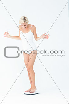 Happy woman standing on a scales