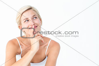 Beautiful blonde smiling with finger on mouth