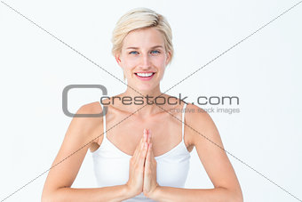 Happy woman doing yoga smiling at camera