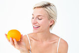 Happy woman holding an orange