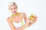 Pretty blonde choosing between eating pizza or not