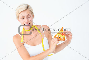 Pretty blonde choosing between eating pizza or not