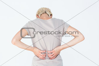Blonde woman having a back ache and holding her back
