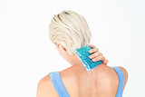 Blonde woman putting gel pack on neck