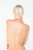 Beautiful topless woman touching her back