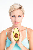 Attractive woman showing half of an avocado