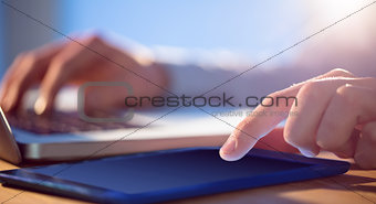 Businessman using laptop and tablet at desk
