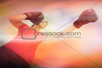 Composite image of fit woman boxing