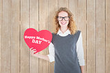 Composite image of geeky hipster holding heart card