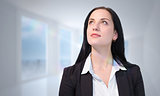 Composite image of pretty businesswoman looking up