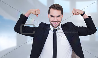 Composite image of happy businessman in suit cheering