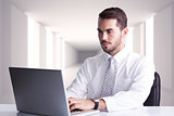 Composite image of cheerful businessman using laptop at desk