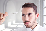 Composite image of focused businessman holding white cable