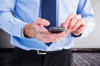 Composite image of close up of a businessman using a smartphone
