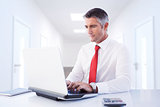 Composite image of businessman using laptop