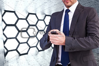 Composite image of focused businessman texting on his mobile phone