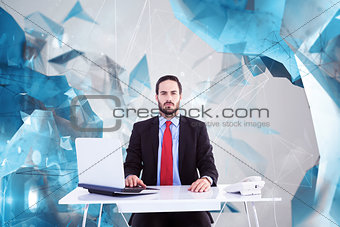 Composite image of unsmiling businessman sitting at desk