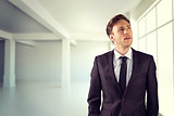 Composite image of young businessman thinking and looking up