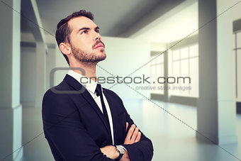 Composite image of thinking businessman with his arms crossed