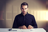 Composite image of serious businessman typing on keyboard