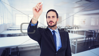 Composite image of businessman holding a chalk and writing something