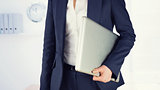 Composite image of businesswoman holding laptop