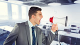 Composite image of businessman shouting in loudspeaker