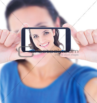 Composite image of pretty brunette taking a selfie