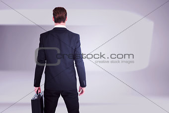 Composite image of rear view businessman standing with his briefcase